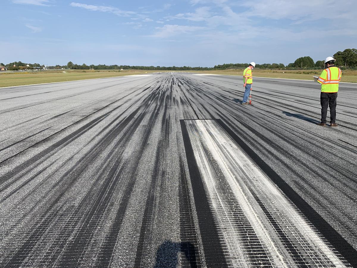 Inspectors reviewing a paved airport runway surface as part of the quality checks involved in airport runway paving