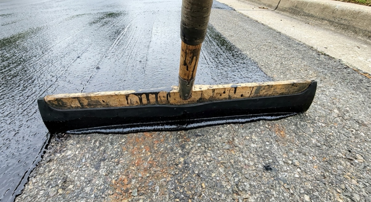 Sealcoat being applied to protect a newly repaved driveway